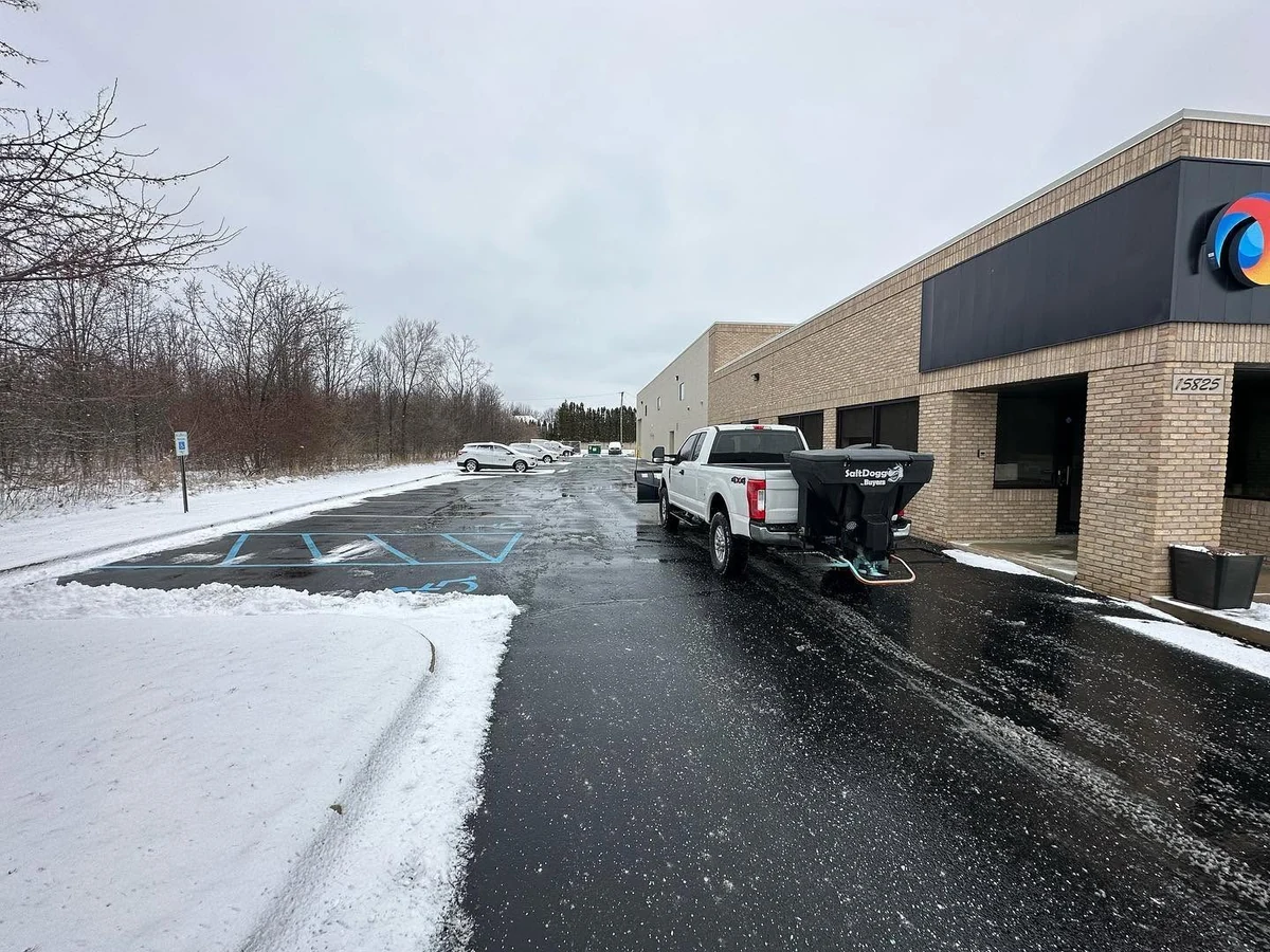 Big Dawgs truck clearing snow and salting a commercial parking lot