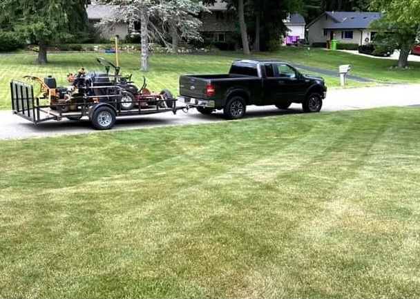 Big Dawgs crew truck and mowing trailer parked at a freshly striped lawn