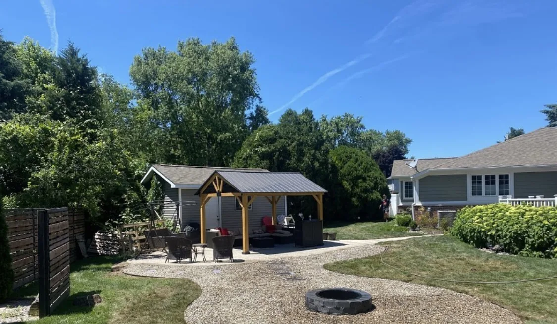 Backyard transformation with fire pit, gravel patio, and pavilion