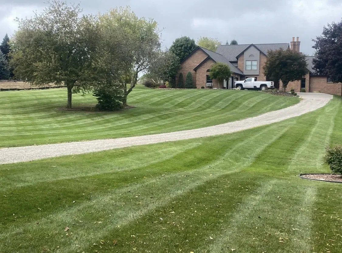 Large professionally striped property beside a gravel drive maintained by Big Dawgs